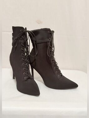 Sleek black lace-up stiletto booties featuring a sharp pointed toe.